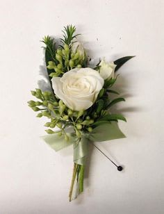 Handmade Boutonn&iacute;ere typically using a spray rose and greenery,
Customizable upon request, availability