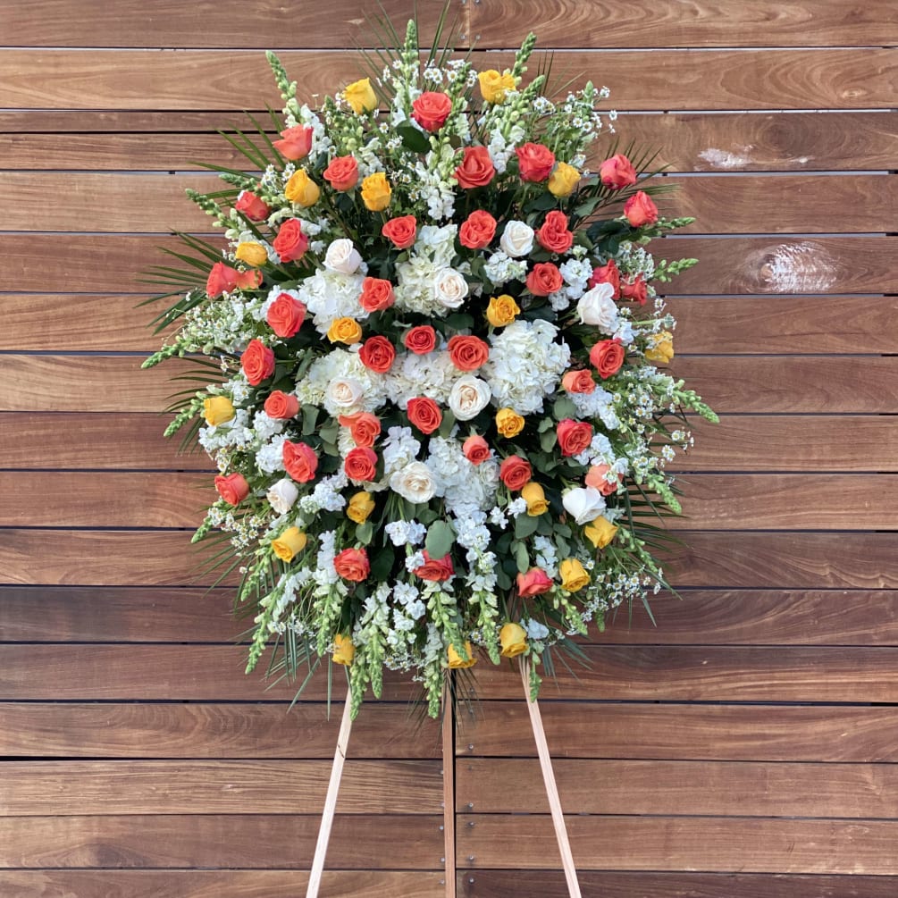 Sympathy easel arrangement with white hydrangeas and different colored roses and additional