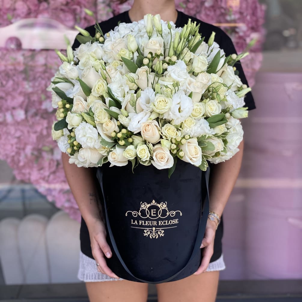 Black signature box with mix flower arrangement of white flowers like hydrangeas