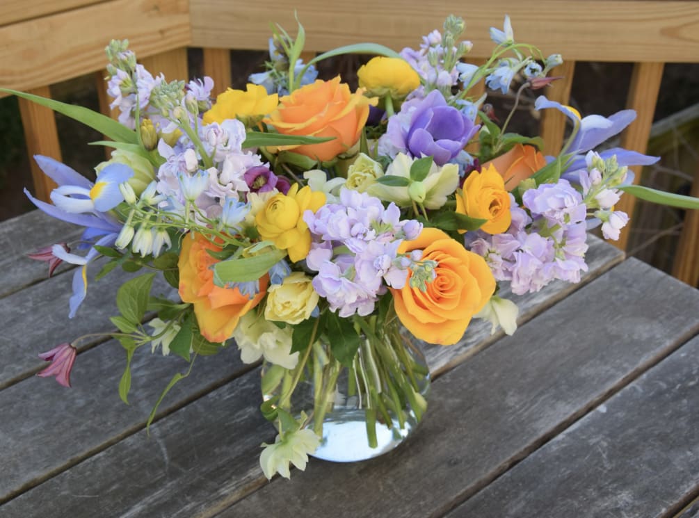 A lovely spring flower arrangement with lavender stock and violet clematis, yellow