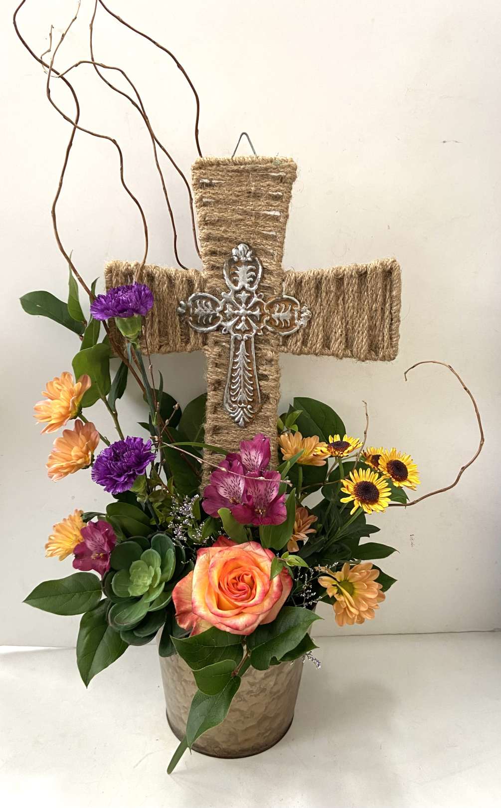 Jute and metal cross with medley of wildflowers.