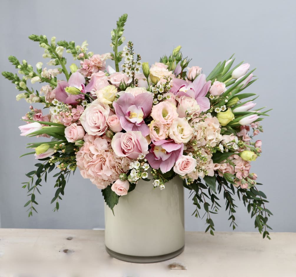 In this pink vase we delicately arrange ranunculus, roses, and seasonal soft