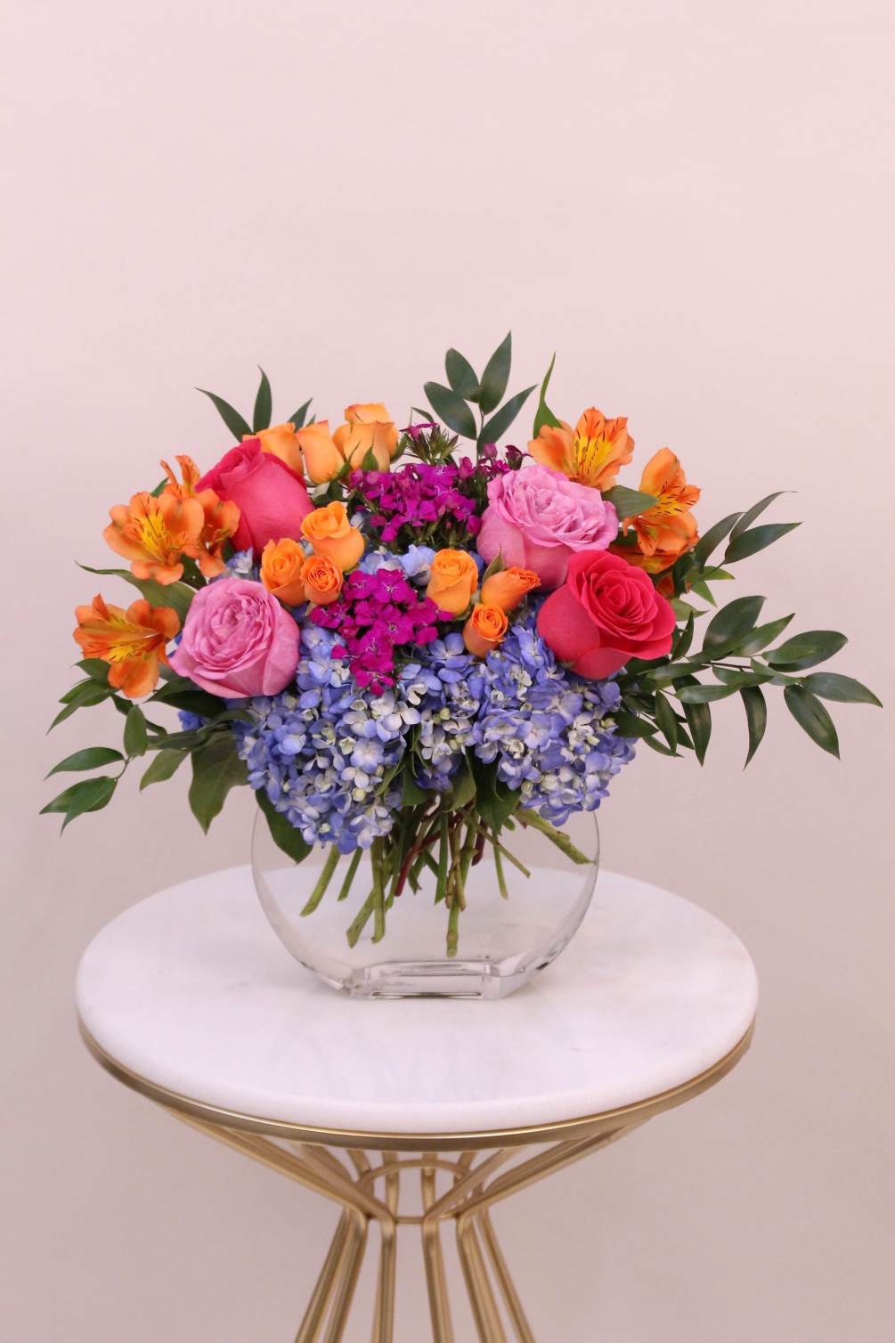 An arrangement of vibrant spring flowers arranged in a square moon glass