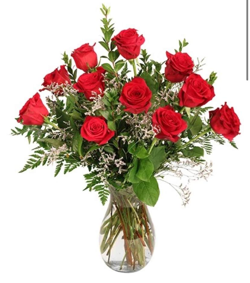 12 roses with greenery and filler in a vase. 