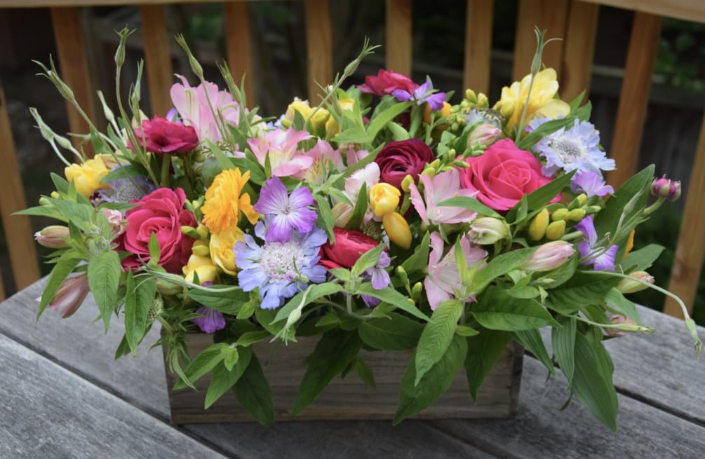 A lovely flower arrangement in a wooden rustic box. The flowers are