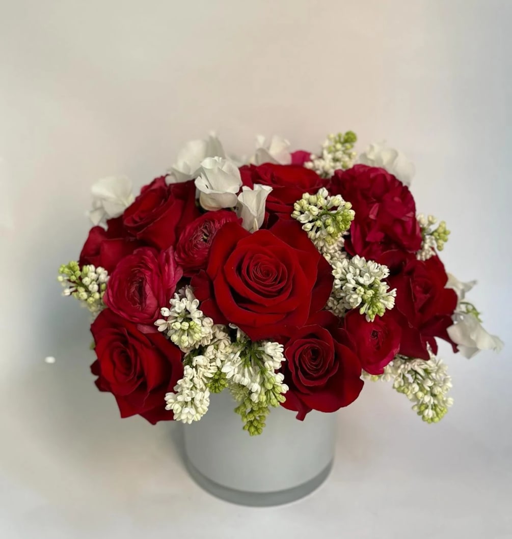 A classic red rose arrangement with beautiful bright ranunculus white accents. Fit