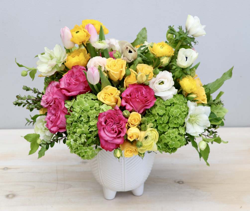 This happy arrangement is made with hot pink roses and yellow and
