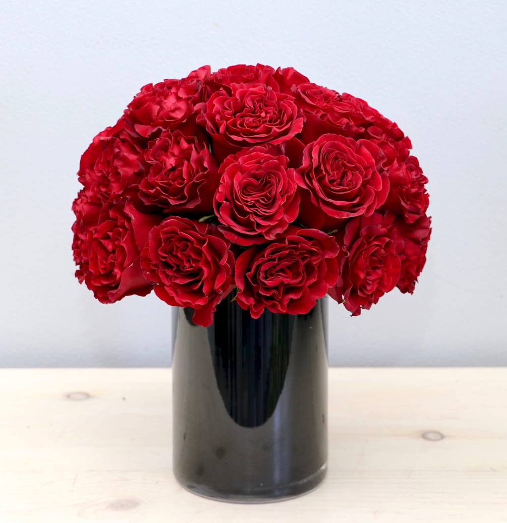 Red garden roses are the highlight of this arrangement, making it the