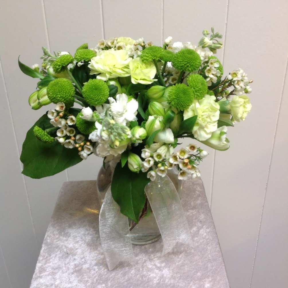 A fun arrangement of green and white flowers in a clear glass