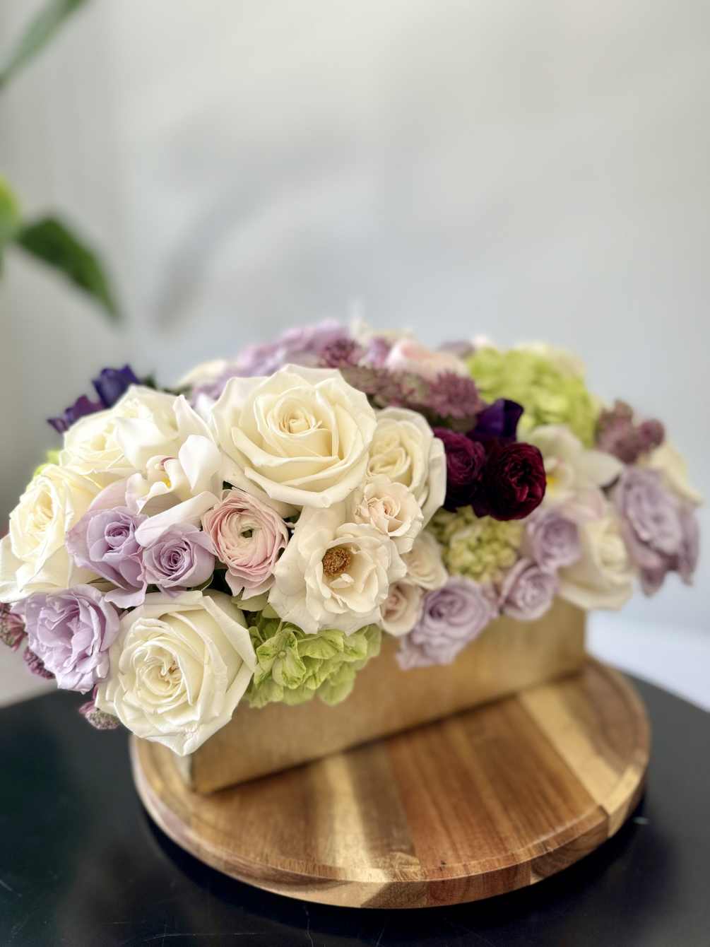 A lush a full arrangement with roses, ranunculus, orchids, hydrangeas and spray