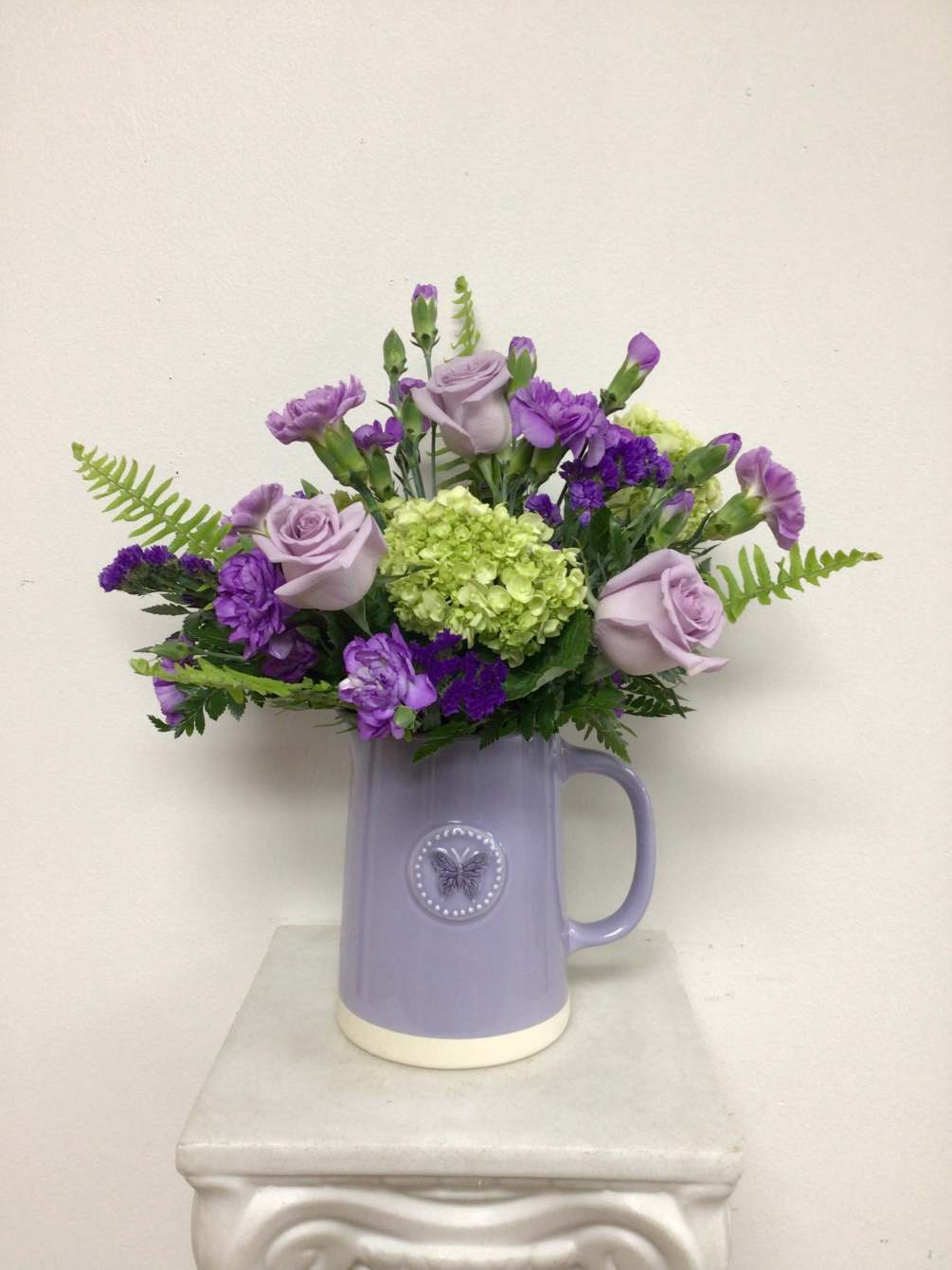 Ceramic lavender pitcher embossed with a butterfly and arranged with lavender miniature