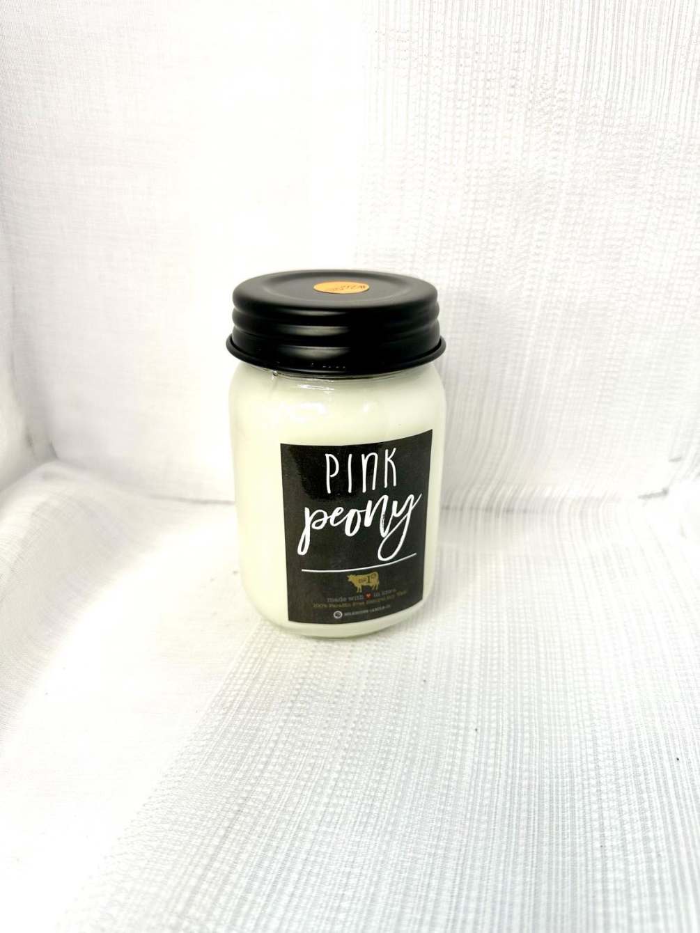 A candle with the scent of sugared peony and velvet apricot blossom