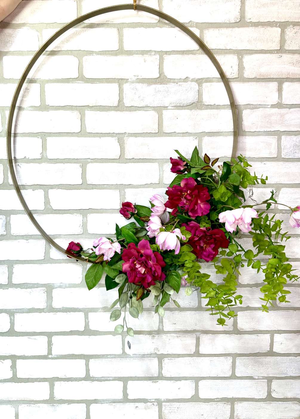 An artificial wreath, hoop, arrangement with hot pink and light pink florals