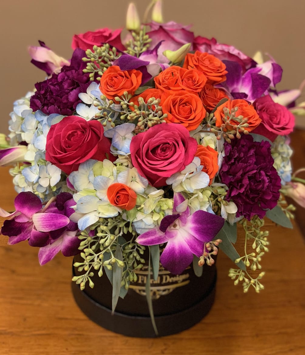 Spray orange and hot pink roses, burgundy carnations, blue hydrangeas, purple orchids