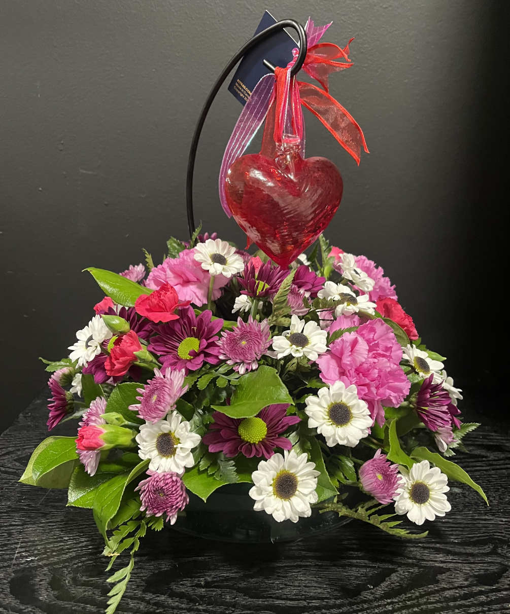 Beautiful Kitas glass heart in a bed of fresh flowers.  Stand
