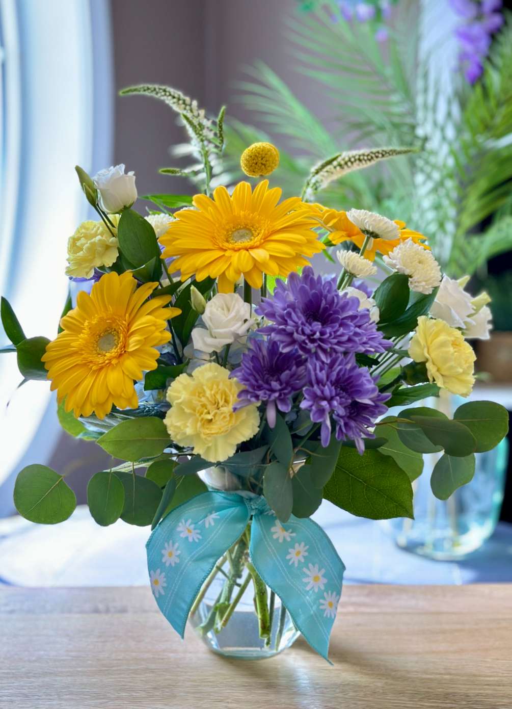 A bright uplifting mix of bright yellow &amp; blue fresh flowers that