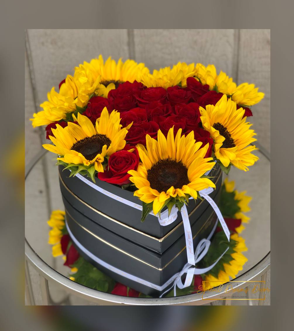 Red roses and sunflowers in a black heart box 
