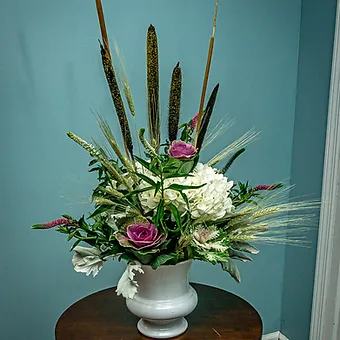 Large white urn filled with white and purple kale, dusty miller, dried