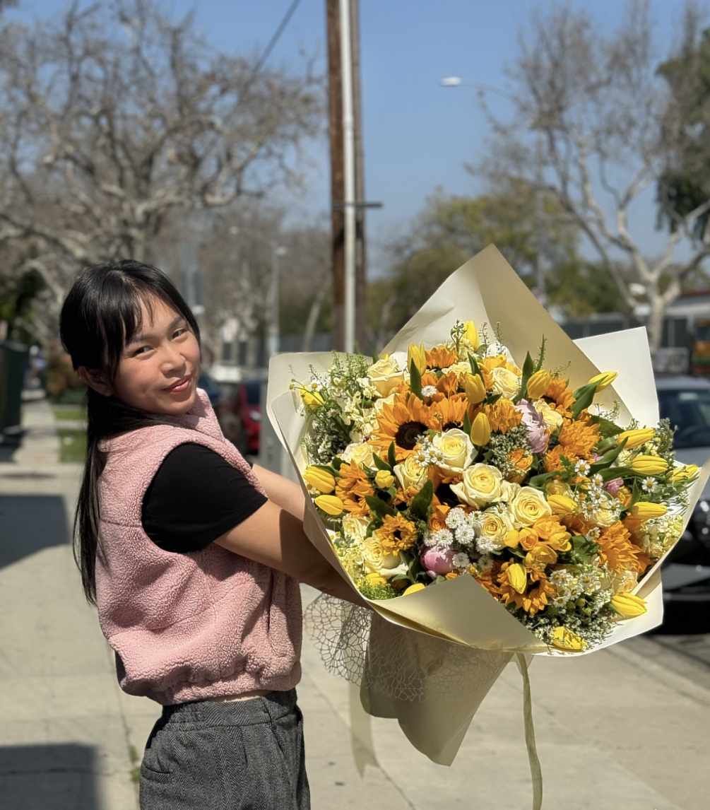 A mega bouquet of yellow flowers including roses, sunflowers, tulips, and other