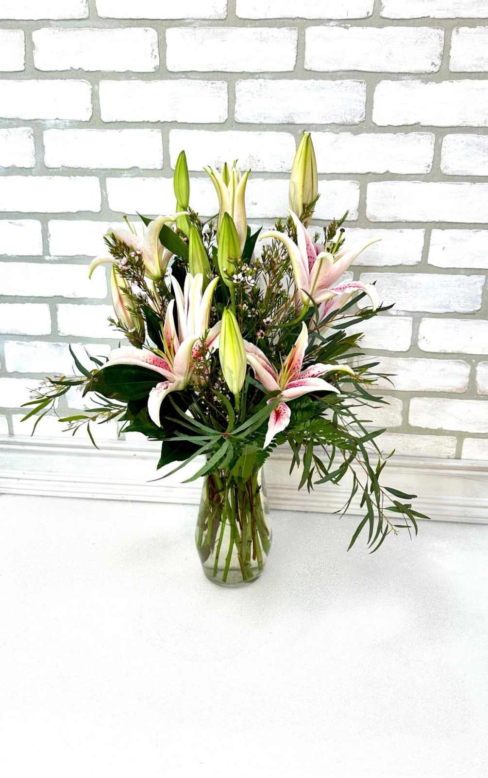 Gathering vase filled with Stargazer lilies. One of our most popular items!