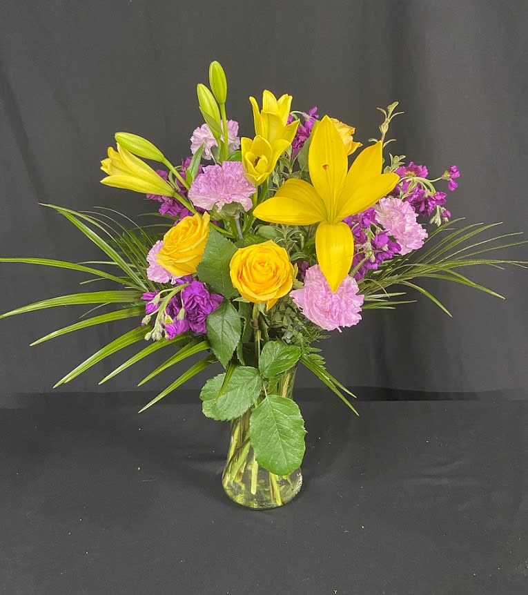 With beautiful golden yellow and deep purple tones, this flower arrangement is
