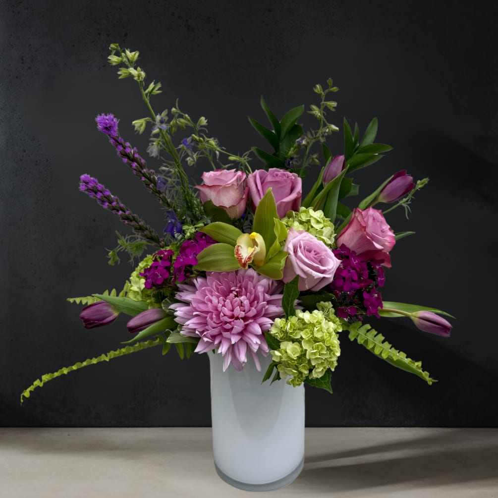 All - Around arrangement, shades of purple-toned blooms accented with bright green