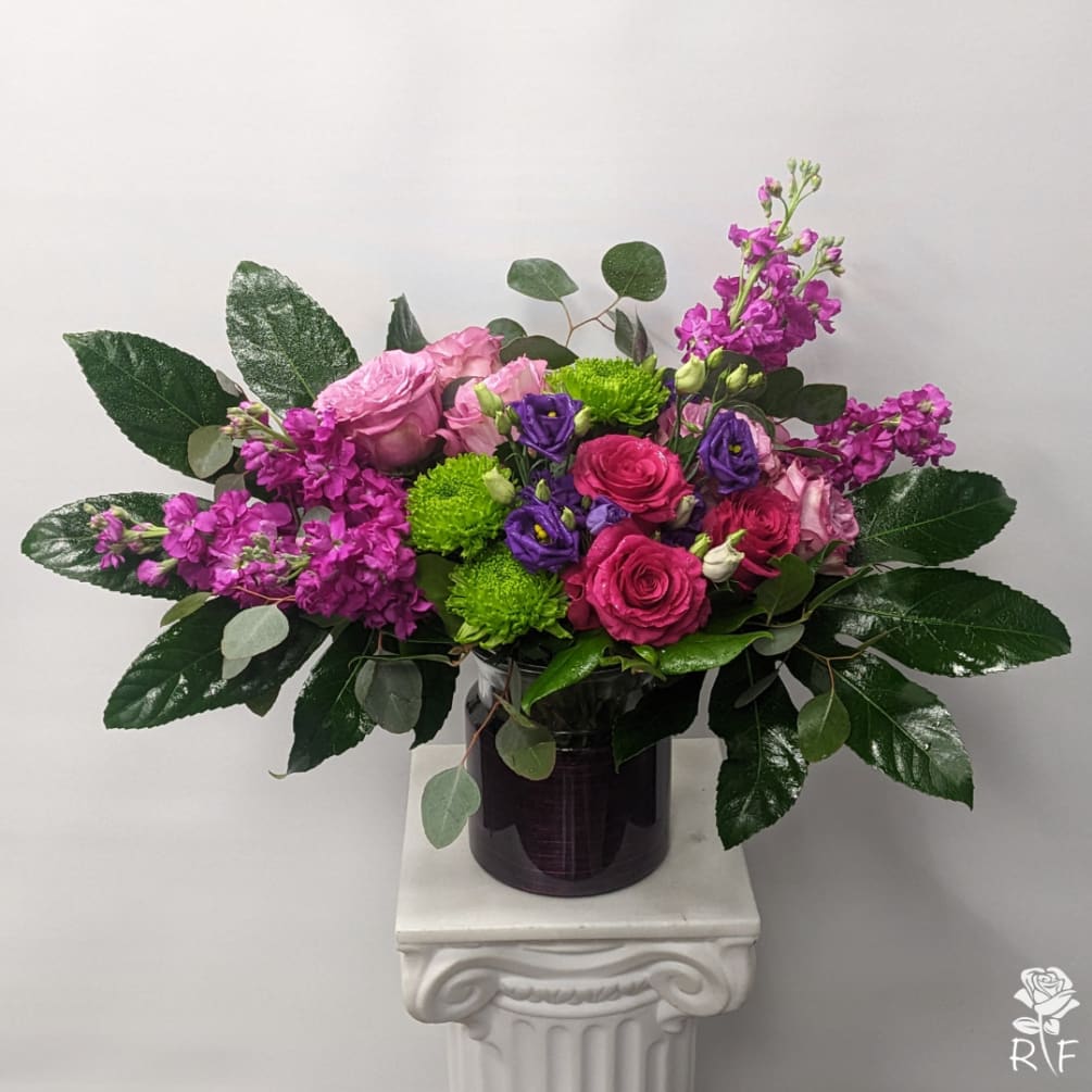 The Pink and Purple floral arrangement is a joyous proclamation of the