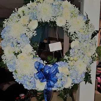 22 inch round wreath with roses, hydrangea, mums and lilies. Can be