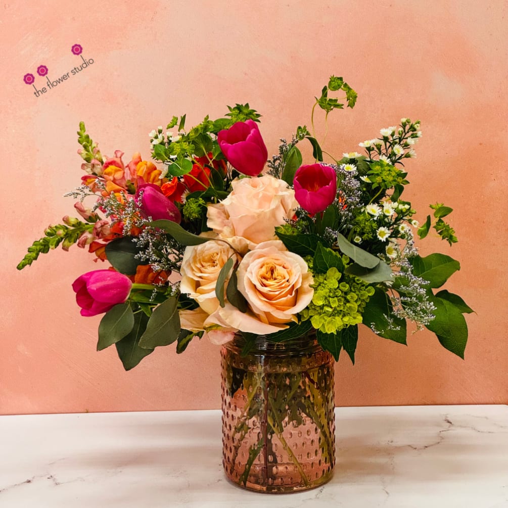 A charming flower arrangement. This peach and pink flower arrangement radiates warmth