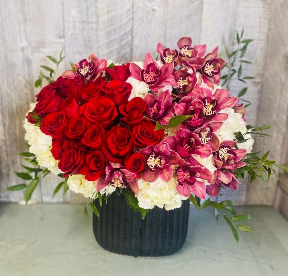 One of our best sellers, this beautiful arrangement features red roses, cymbidium