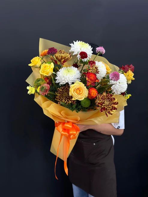 The Golden Dream bouquet is composed of high-quality roses, mums, olaya, ranunculus