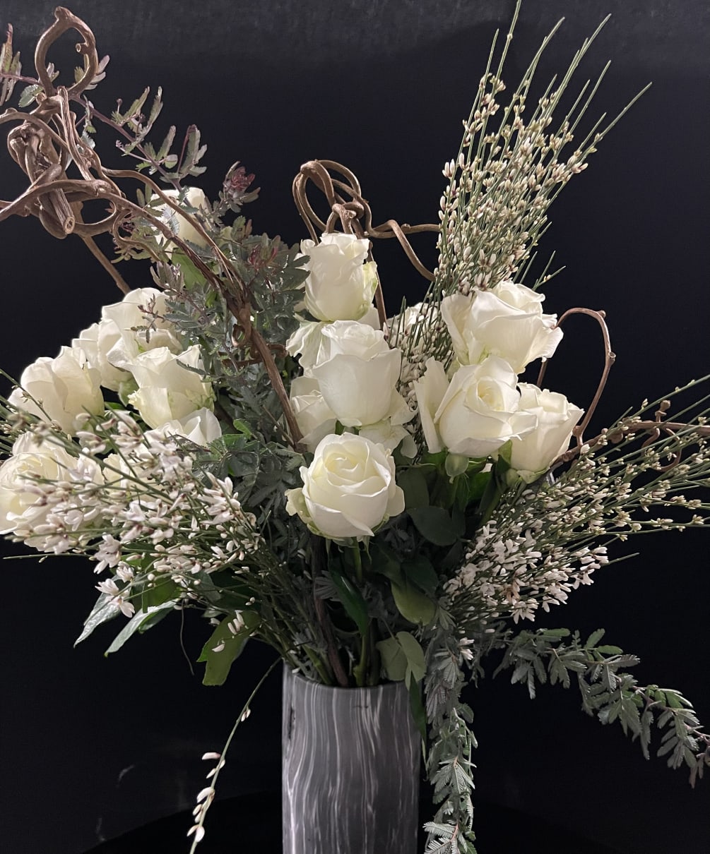 Tall two dozen in stunning vase and surrounded by beautiful greens and