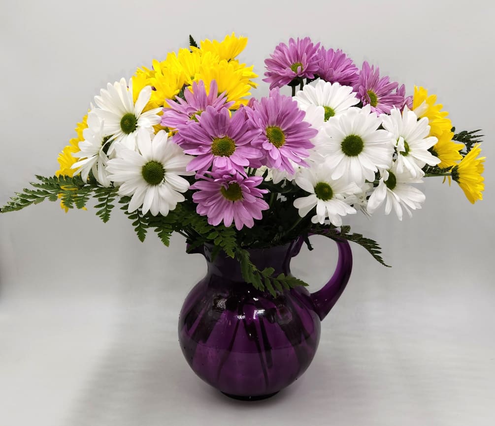 Smiles delivered in this simple purple pitcher filled with daisies