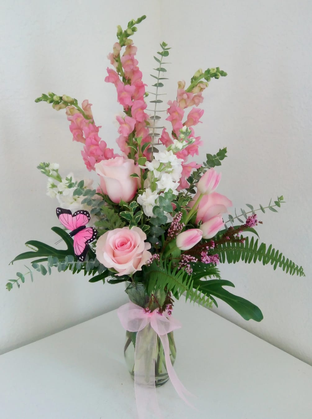 Pinks and whites arranged in a tall clear vase
