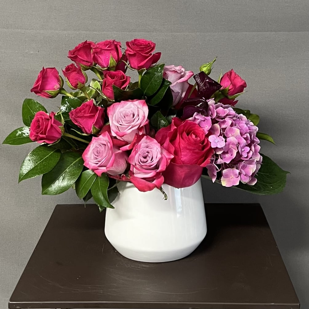 This floral design has roses, hydrangeas, and mini calla lilies. This arrangement