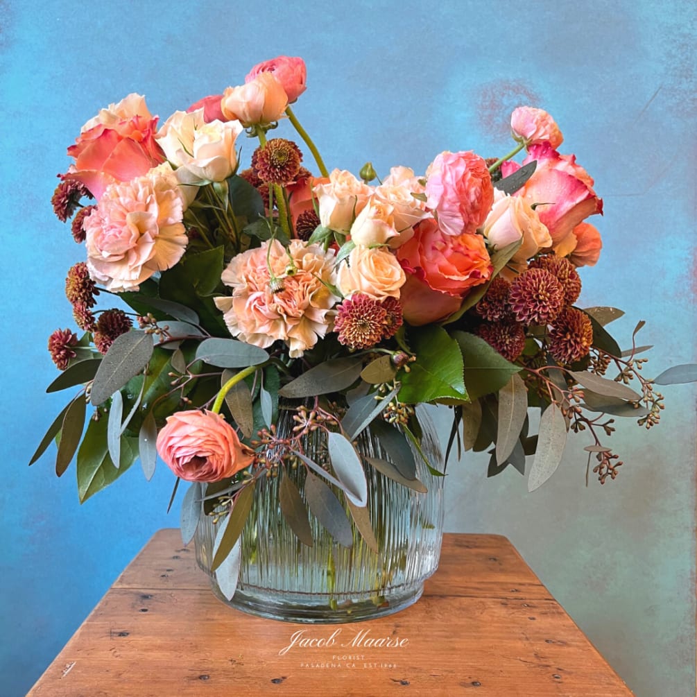 A sweet mix of seasonal flowers using hues of apricot, peach, and