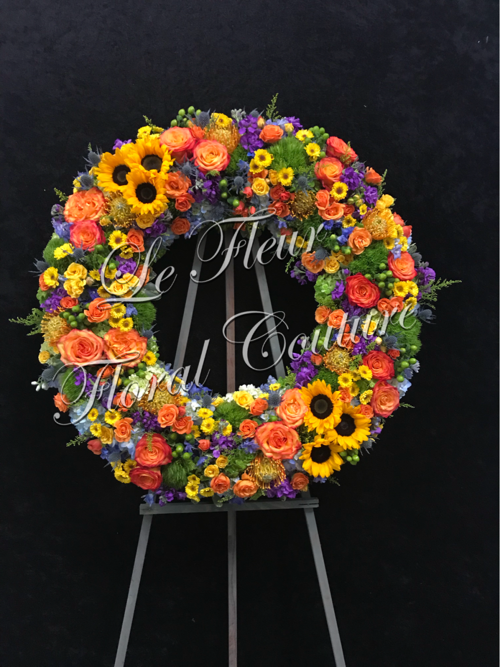 A beautiful sympathy wreath filled with various vibrant flowers of spring mixed
