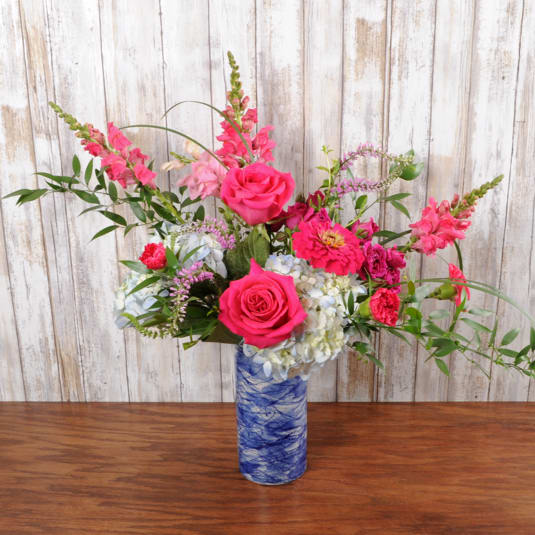 Blue swirl ceramic keep sake vase holds beautiful bright blooms