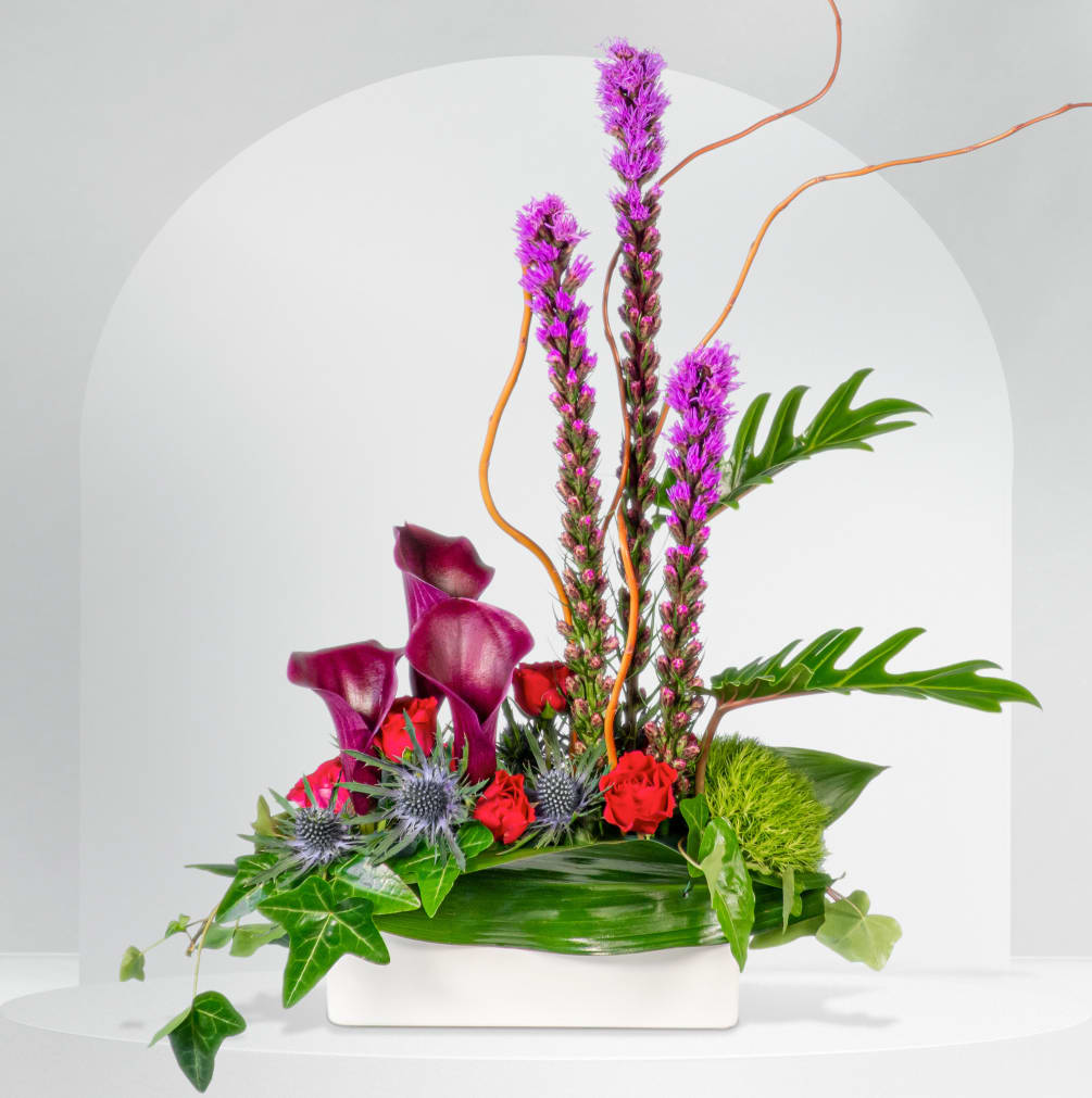 This unique design includes calla lilies, liatris, spray roses, thistle, and tropical