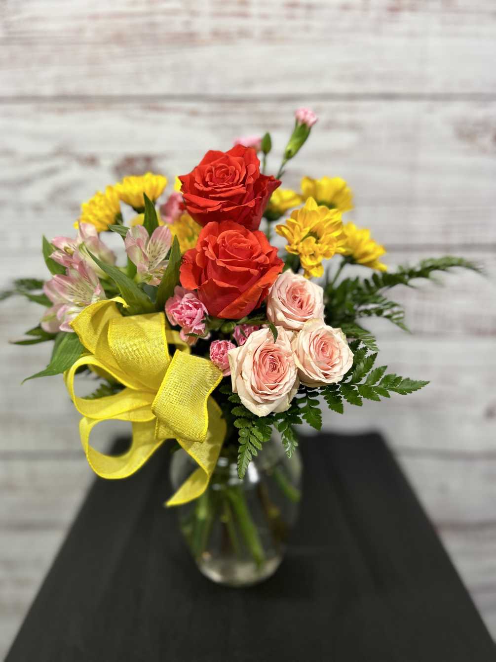 This lovely bouquet of orange roses, pink alstroemeria and pink spray roses