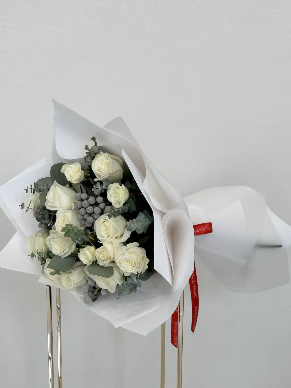 This stunning bouquet of pristine white roses captivates with its timeless elegance