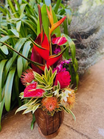Prearranged mixed tropical arrangement in a genuine coconut shell.