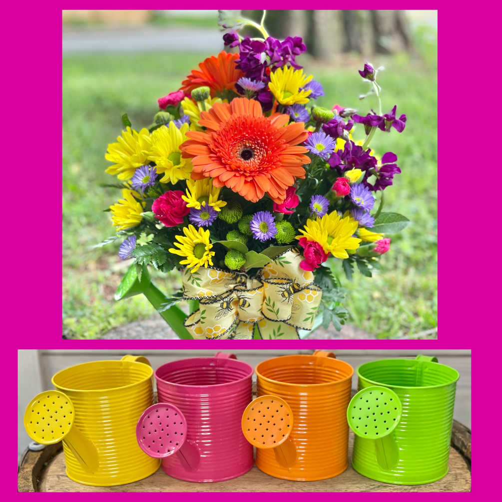 A mix of seasonal flowers in a colorful watering can. ****We will