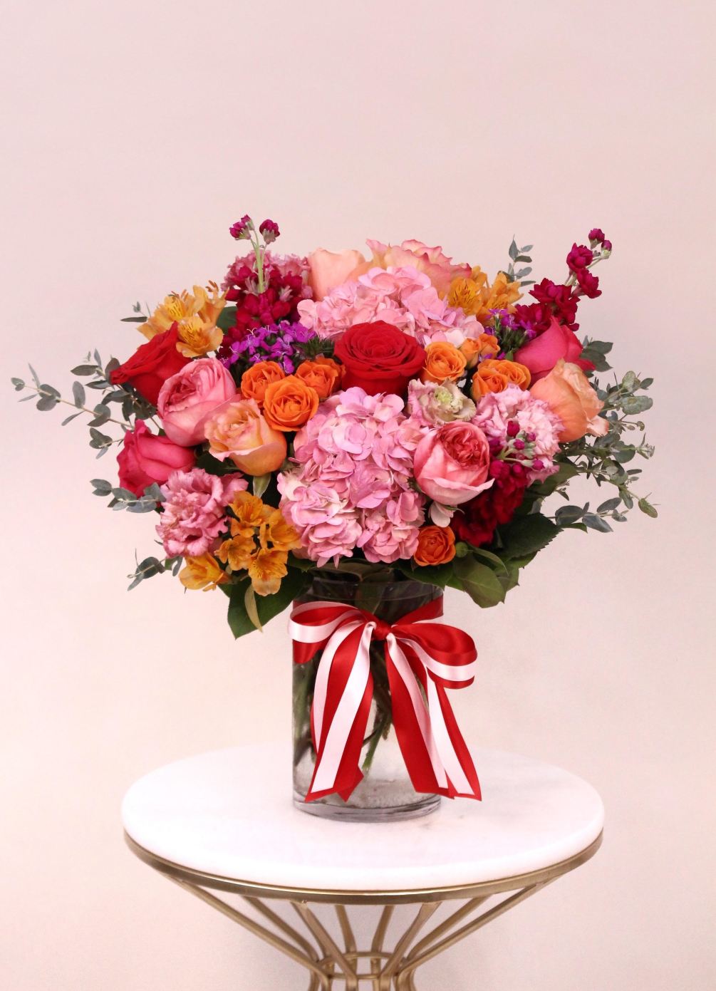 This beautiful arrangement with shades of red, pinks, purple, orange and magenta