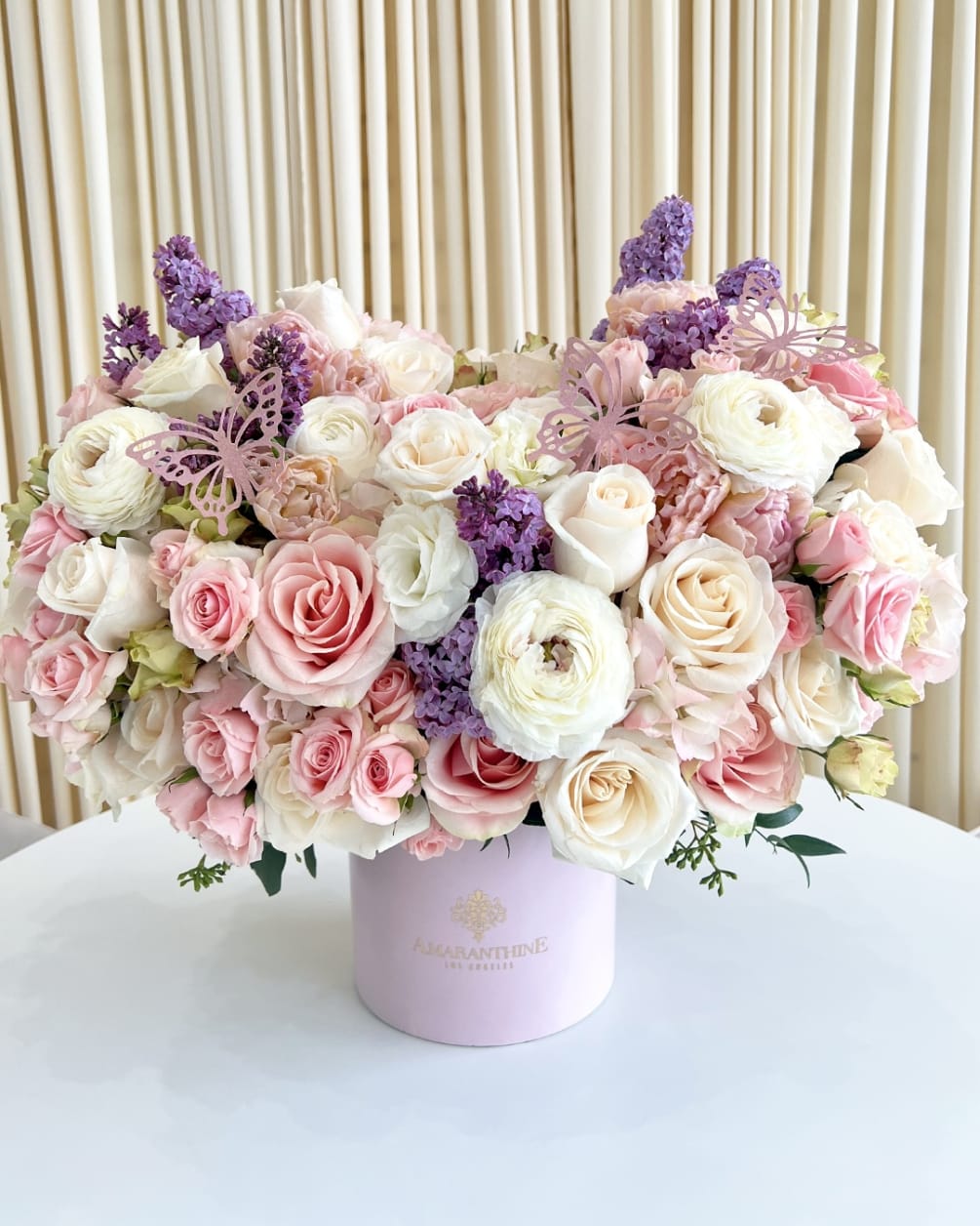 This beautiful flower arrangement features a mix of pink, purple, and white