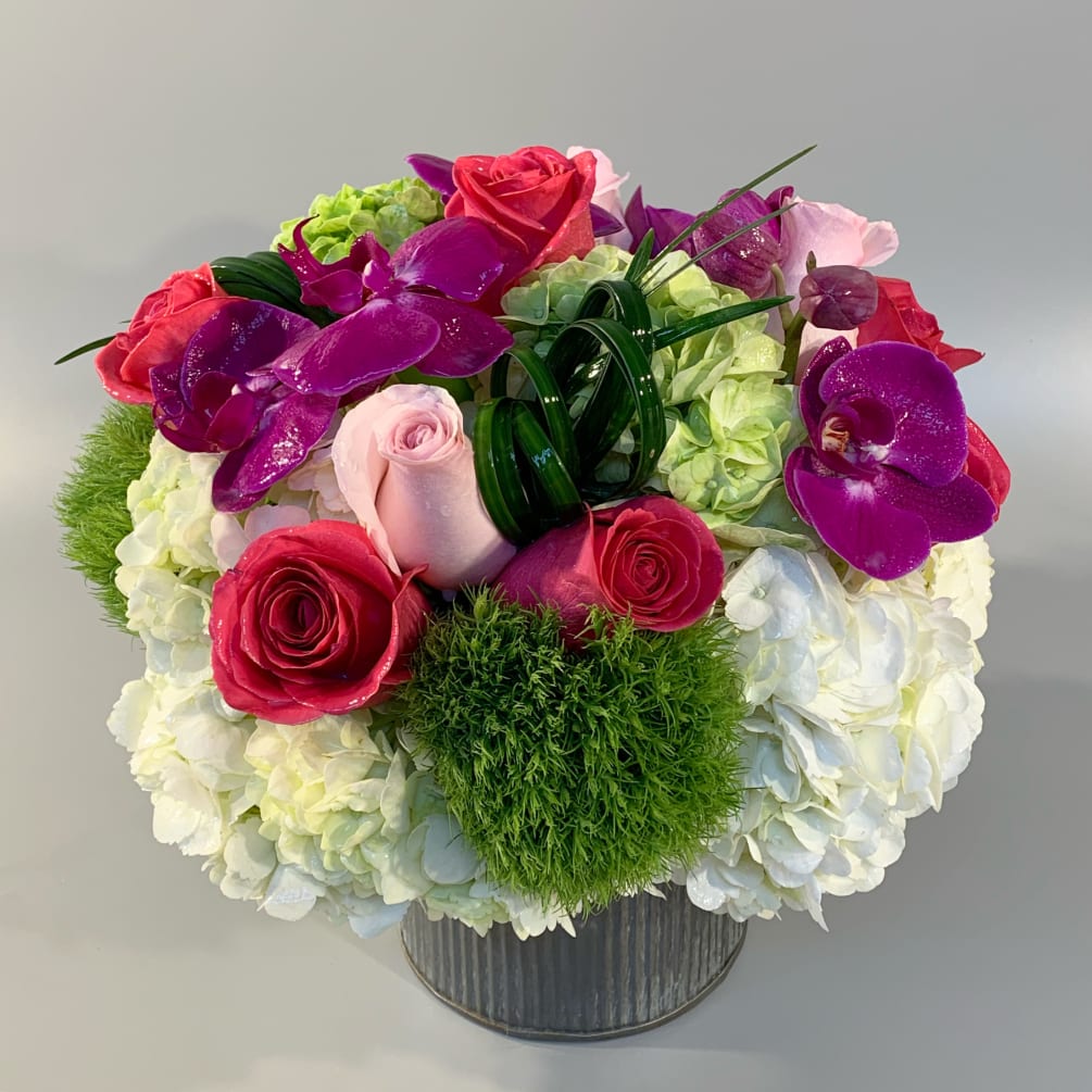 A combination of seasonal textures of roses, dianthus, succulents, and designed in