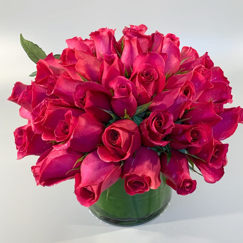 A modern, lush, luxurious hand-tied arrangement of nearly 50 fresh roses designed