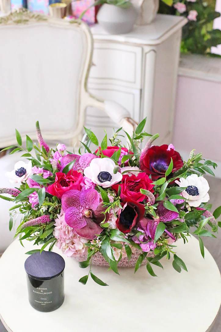An enthralling spring floral arrangement boasting exquisite magenta vanda orchids, burgundy and