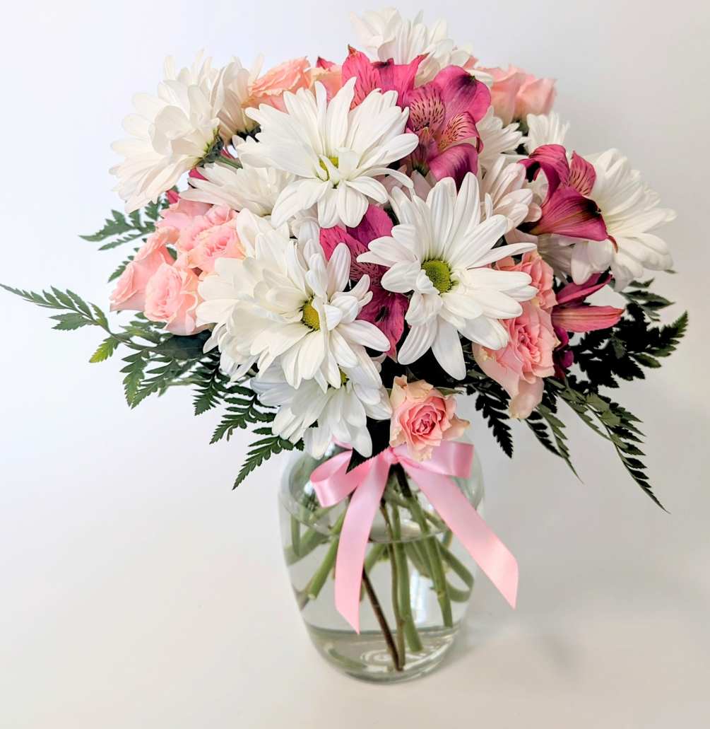 Perky, fresh white daisies dance along with pretty pink spray roses and
