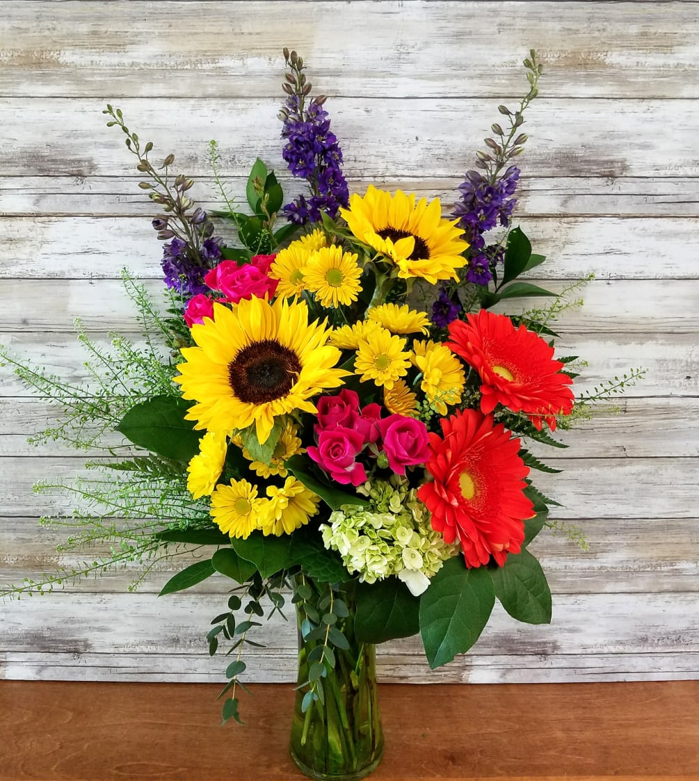 Bright bold colors will surely make them smile!

Gerbera daisies, sunflowers, hydrangea, spray